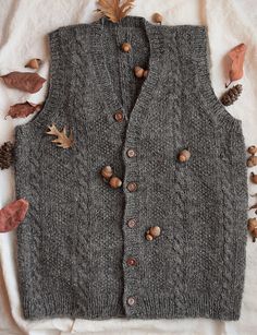 a gray sweater vest with buttons and leaves on it