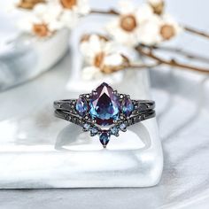 an image of a ring with blue and purple stones in it on a white plate