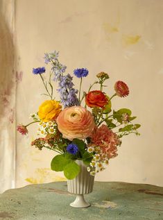 a vase filled with lots of different colored flowers