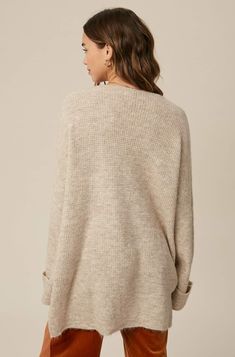 So chic and effortless, this slouchy, oversized tunic-style sweater features a v-neckline and dropped wide sleeves for added shape. -Available in Stone & Misty Blue -Waffle textured -V-neck -Oversized fit -Soft touch eyelash two tone yarn -Long sleeve with folded cuffs -Side slits -Ribbed on hem -Content: 74% Acrylic 22% Polyester 4% Lycra -Hand was cold/Line dry -Imported -Model is 5 8" 32-24-34 and wearing a size Small