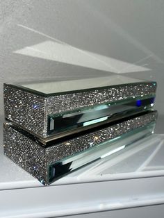 two crystal boxes are stacked on top of each other, one is shiny and the other is sparkling