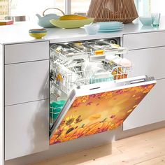 an open dishwasher in a kitchen with dishes on the counter