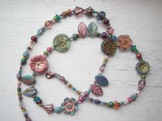 A Czech glass flower and leaf necklace.. slightly asymmetrical Shades of muted blues, dusty mid and light pinks, sage green, aqua, some plum, and mauve. Flowers, leaves, small glass, and various seed beads make up this necklace, with a copper plated lobster claw clasp. 19" in length, largest flowers are 14mm in diameter.   If you would like a little more room, please message me and I will add a 2" extension chain at no extra cost. Czech Beads Jewelry, Beaded Flower Necklace, Mauve Flowers, Czech Glass Necklace, Boho Layering, Green Aqua, Leaf Necklace, Flowers Leaves, Fantasy Jewelry