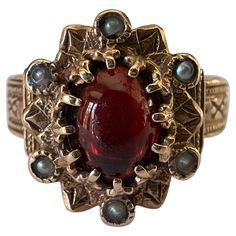 This beautiful antique Victorian ring features a natural oval-shaped cabochon garnet accented by six seed pearls set in an ornate band with fine hand engraving fashioned from 14K yellow gold. The markings on the band indicate the ring was most likely manufactured in Europe. Circa late 19th century. Antique Rings Victorian Silver, Luxury Victorian Oval Pearl Ring, Antique Rings Victorian 1stdibs, Antique Engagement Rings Victorian, Victorian Wedding Ring, Antique Rings Victorian, Natural Pearl Ring, Georgian Ring, Seed Pearl Ring