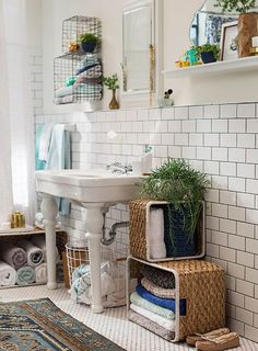 a bathroom with a sink, toilet and rugs on the floor in front of it