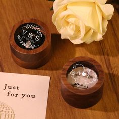 a wooden box sitting on top of a table next to a white rose and greeting card