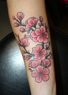 a woman's arm with pink flowers on it