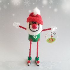 a knitted toy is holding a christmas ornament