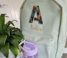 "Personalised toddler backpack These personalised toddler backpacks are embroidered with initial and name. They can be used as small nursery backpacks as they are compact enough to fit all of your little ones essentials and also stylish and easy to wear. They make great back to school bags as they are custom to your little ones interests.  The rucksacks are a perfect nursery bag with the embroidered and appliquéd completed to a professional standard.  This \"Asher\" backpack uses Jungle fabric, Signature Font and Gold Thread.  With a range of fabrics you can have a fairy toddler backpack or a girly flower or unicorn backpack or the complete opposite with a planets and space design backpack or green dinosaur toddler backpack. If you have a completely different design in mind we can provide Jungle Flowers, Nursery Bag, Small Nurseries, Unicorn Backpack, Back To School Bags, Embroidered Initials, World Party, Safari Jungle, Toddler Backpack