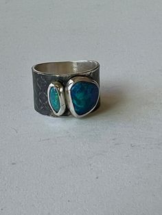 Two beautiful black opals bezel set in sterling silver with a wide band of black patinated, textured sterling silver. The opals measure approximately 10 x 8 and 8 x 3mm. The band is 12mm wide and a size 7-1/2.  Or113 Silver Stone Rings, Silver Color Palette, Silver Smithing, Dream Rings, Boulder Opal Ring, Diy Jewelry Rings, Simple Silver Jewelry, Australian Black Opal, Black Opal Ring