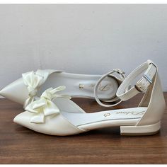 a pair of white shoes sitting on top of a wooden table