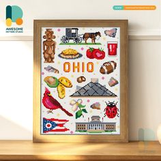 the cross stitch pattern is displayed in a wooden frame