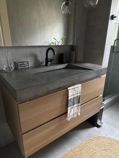 a bathroom with a sink, mirror and towel on the counter next to glass doors