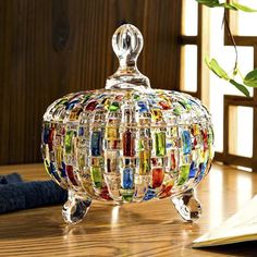 a glass covered jar sitting on top of a wooden table