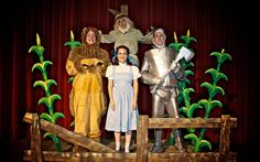 three people dressed in costumes standing on a stage