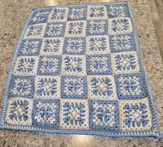 a blue and white crocheted blanket sitting on top of a granite countertop