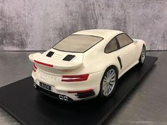 a white sports car is sitting on a black stand and it's made out of plastic