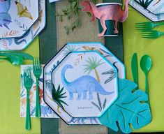 dinosaur plates and forks on a table with green napkins