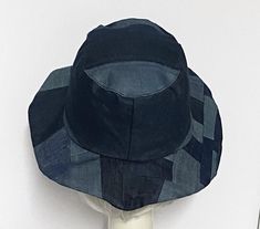 Bucket hat denim, inside black 1" cotton band, the hat has a 2 section crown 3 1/2 " in length and a one piece patchwork 3" brim, and is lined in a cotton blend print. Each hat is unique with repurposed pieces of denim that are used and each hat may slightly vary Made in USA One size fits most up to 23" Machine wash cold / hand dry Adjustable Cotton Patchwork Hat, Black Reversible Sun Hat With Curved Brim, Fitted Cotton Hat With Curved Brim, Fitted Cotton Bucket Hat, Black Reversible Brimmed Hat, Black Reversible Hat With Curved Brim, Black Reversible Curved Brim Hat, Beret Hat Bow, Patchwork Bucket Hat