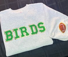 Philadelphia Eagles Gear! BIRDS patch letters iron on and stitched on for extra support on an over sized crewneck. Green letters with a Gold Glitter Trim. Brown Football patch on the sleeve. Philadelphia Eagles Crewneck, Football Eagles, Philadelphia Eagles Gear, Crafts 2024, Patch Letters, Philadelphia Eagles Shirts, Eagles Gear, Eagles Sweatshirt, Green Letters