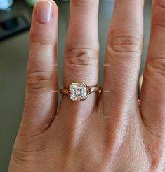 a woman's hand with an engagement ring on it