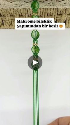 a hand holding a green glass wind chime