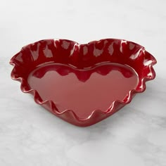 a red heart shaped dish on a white table