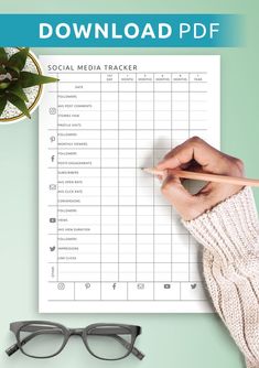 a person's hand holding a pencil over a social media tracker