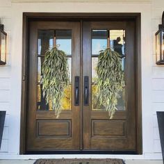 the front door is decorated with wreaths and hanging from it's sidelights