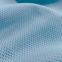 close up view of the texture of a blue knitted fabric with horizontal lines on it