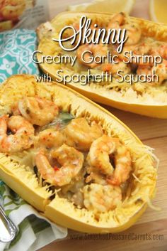 two halves of spaghetti dish with shrimp in them on a wooden table next to lemon wedges