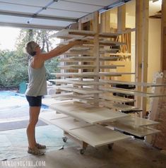 a woman is working on some shelves in the garage