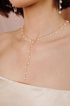 Looking to elevate your entire look? Look no further than our gold Whispering Pearl Lariat Necklace! This dainty gold feminine piece features delicate freshwater pearls that gently cascade, offering a refined yet minimalist look. Perfect for the modern bride, the Whispering Pearl Lariat Necklace is a versatile accessory that will level up your wedding look (and beyond) beautifully! ----------------------  NECKLACE FEATURES ◊ Material: Brass, Freshwater Pearls ◊ Dimensions/Size: 16" with 2" Exten Wedding Necklaces With Clavicle Chain, Wedding Necklace With Clavicle Chain, Wedding Long Necklace With Clavicle Chain, Long Clavicle Chain Necklace For Wedding, Wedding Clavicle Chain Long Necklace, Yellow Gold Single Strand Necklace For Wedding, Delicate Bridal Necklace For Parties, Wedding Long Clavicle Necklace, Wedding Backdrop Necklace With Clavicle Chain