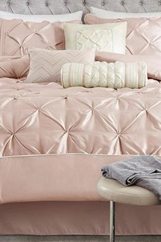 a bed with pink comforters and pillows on it