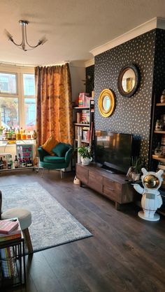 a living room filled with furniture and a flat screen tv sitting on top of a hard wood floor