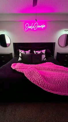 there is a bed with pink blankets and pillows on it