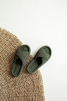 a pair of green slippers sitting on top of a rug