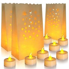 many lit candles are in front of small bags with stars on them, as well as one candle