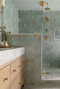 a bathroom with blue tile and gold fixtures