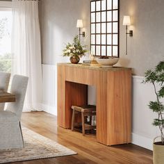 a dining room with a table and chairs next to a potted plant in the corner