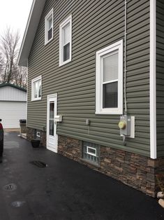 a car is parked in front of a house with two windows on the side of it