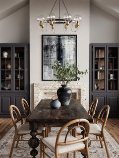 a dining room table with chairs and a potted plant on it in front of a fireplace