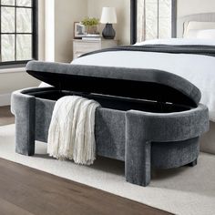 a bed with a large gray ottoman underneath it