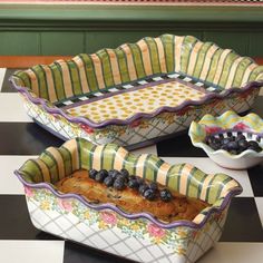 three ceramic dishes with fruit in them on a checkered table