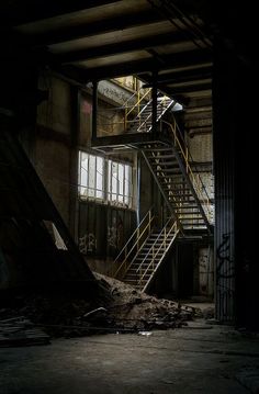 an abandoned building with stairs and graffiti on the walls