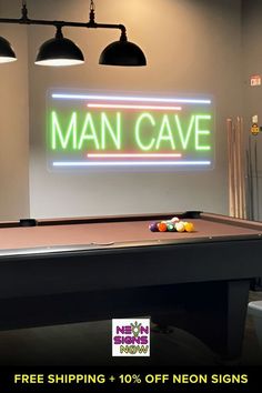 a man cave neon sign on the wall above a pool table