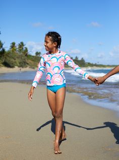 Ready for any day under the sun? Tea's got them covered: Our rainbow, long sleeve rash guard features UPF 40+ for extra sun protection. Matching family styles are available in our Sibling Shop. White Swimwear For Ocean Activities And Beach Season, White Swimwear For Ocean Activities During Beach Season, Upf 50+ Swimwear For Ocean Activities, Upf 50+ Swimwear For Ocean Beachwear, Upf 50+ Beachwear For Ocean Activities, Playful Swimwear With Upf 50+ For Ocean Activities, Playful Swimwear With Uv Protection For Ocean Activities, Long Sleeve Swimwear With Upf 50+ For Play, Casual Rash Guard With Uv Protection For Playwear