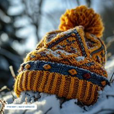 a knitted hat sitting on top of snow covered ground