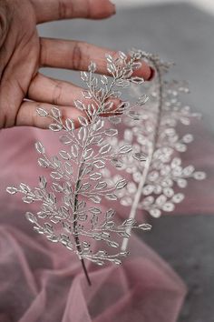 a person is holding a silver plant in their hand