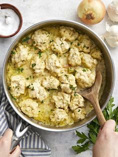 a pan filled with cauliflower and meatballs next to garlic, onions and parsley